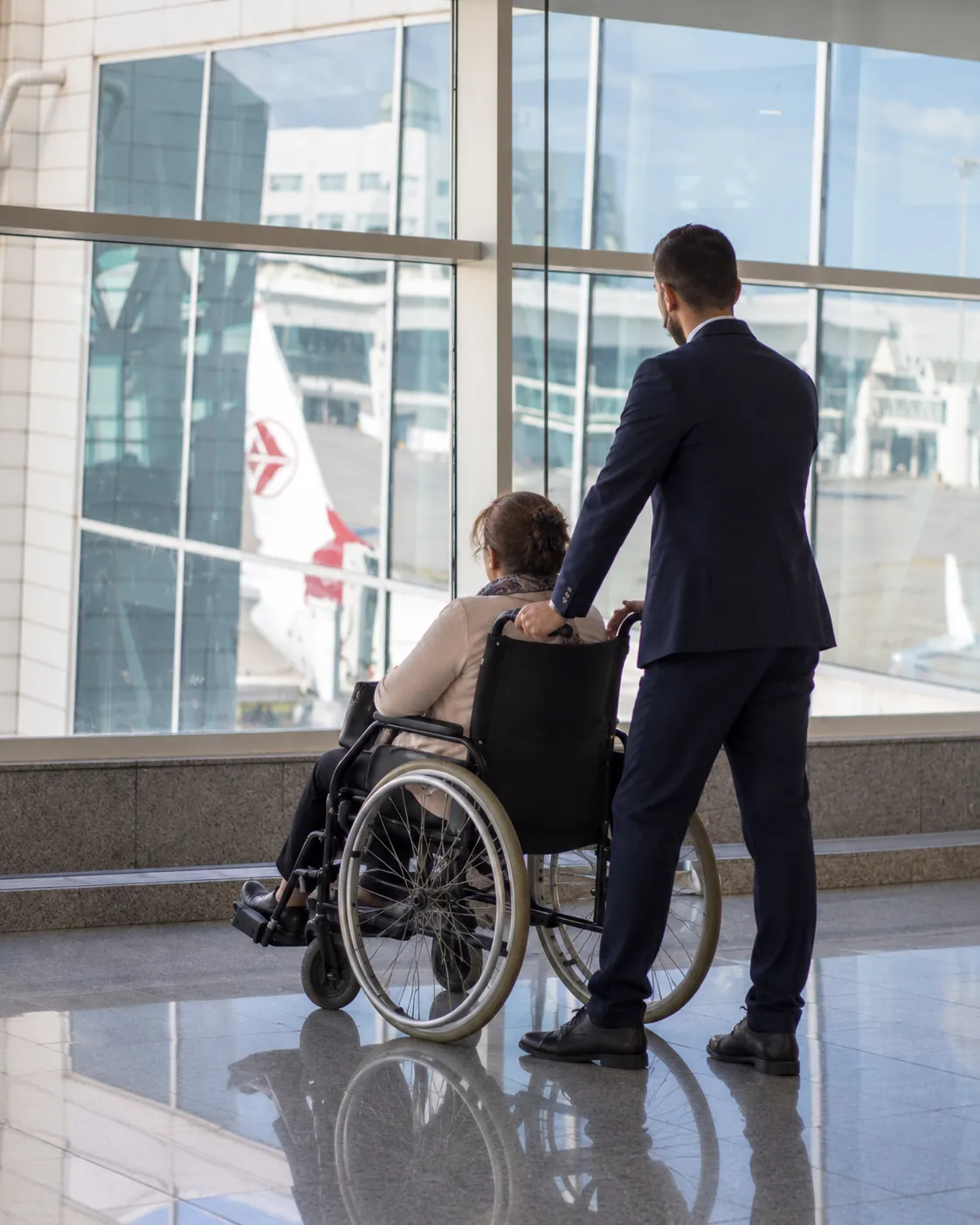Agent accompagnant un voyageur en fauteuil roulant